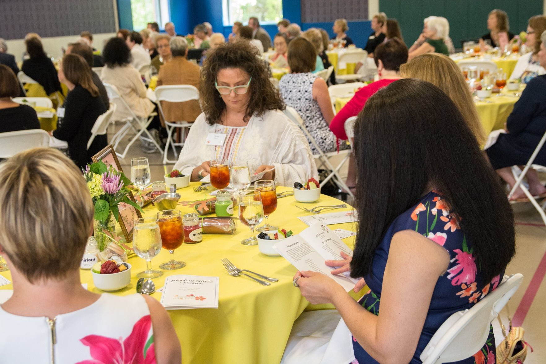 Guests look over the booklet for the luncheon